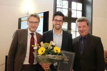 Bild vergrößern: Prof. Dr. Jens Strackeljan (l.) und OB Dr. Lutz Trümper (r.) mit dem Stipendiaten Lauro Fialho Müller
