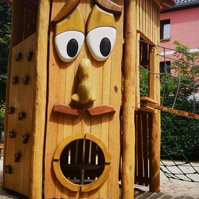 Das hölzerne Gesicht mit Walmdach als Hut auf dem Spielplatz Schneidersgarten