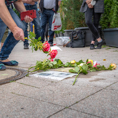 Frau legt Blumen an frisch verlegte Stolpersteine in Magdeburg nieder