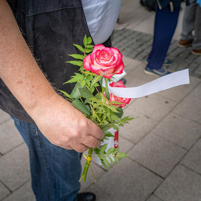 Mensch mit einer Rose zum Gedenken in der Hand