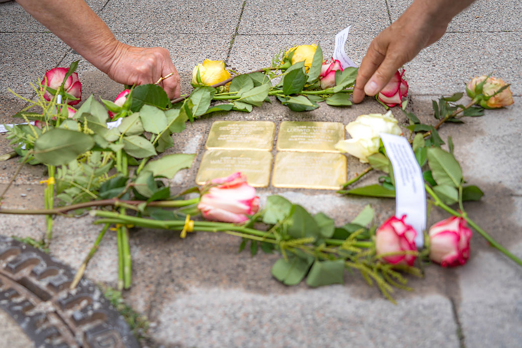 Menschen legen Blumen zum Gedenken an Stolpersteine in Magdeburg