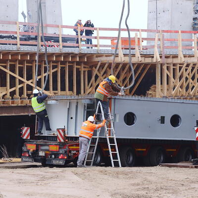Arbeiter befestigen die 60 Tonnen Ankerbox an Stahlseilen für den Spezialkran