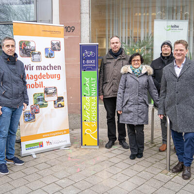 Gruppenbild vor der E-Bike-Ladestation mit dem Beigeordneten Jörg Rehbaum