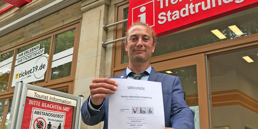 Lars Deutrich, Leiter der Tourist Information, mit dem neuen ZertifikatMagdeburg Marketing