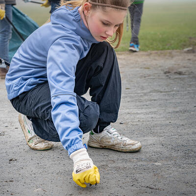 Ein Mädchen sammelt Müll zur Magdeburger Frühjahrsputzaktion 2024
